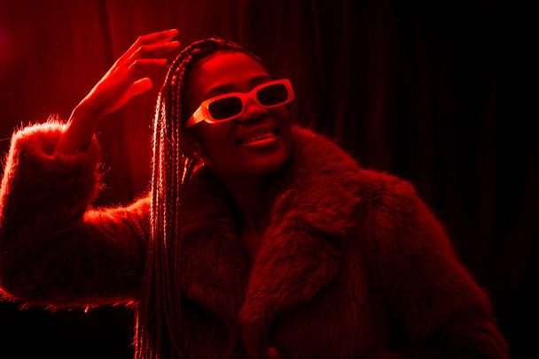 African young woman with braids with red led lights, trap dancer dancing - Foto, afbeelding