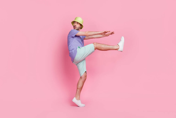 Full size photo of handsome young guy look back empty space sneaking danger dressed trendy blue garment isolated on pink color background. - 写真・画像