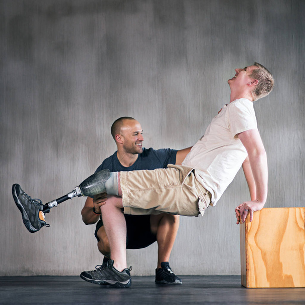 Thats it One more. a physiotherapist helping a young male amputee workout - Foto, Bild