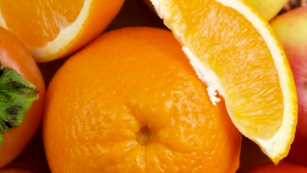 Narancs és sárga színű gyümölcsök - alma, datolyaszilva, körte és narancs, felülnézet. - Felvétel, videó