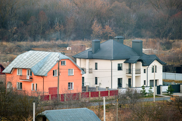 Casas residenciais com telhado coberto com telhas metálicas e cerâmicas na área suburbana rural. - Foto, Imagem