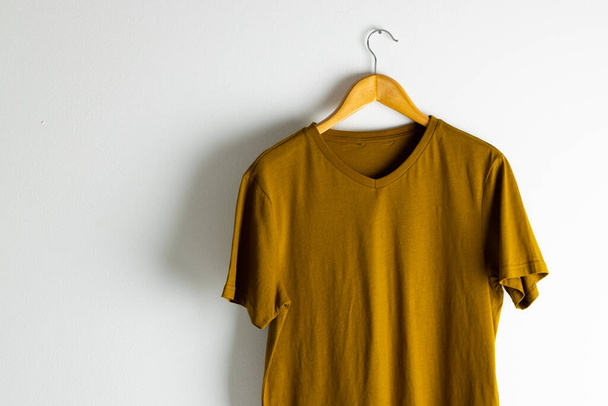 Tshirt hanging on coat hanger and copy space on white background. Clothing, fashion and retail concept. - Photo, image