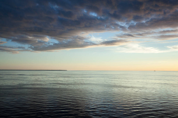 Живописный закат Рижского залива с впечатляющим облачным пейзажем (Латвия)). - Фото, изображение