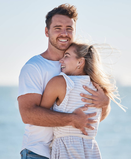 Love, beach hug and couple smile on romantic ocean holiday trip together for relationship bonding, romance and peace. Face of happy man, woman with a smile and nature summer water vacation by the sea. - Фото, зображення