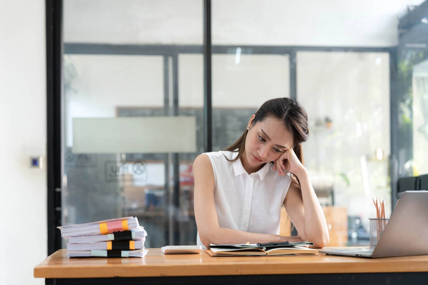 Mladé obchodní asijské ženy jsou ve stresu při práci na notebooku, unavené asijské podnikatelky s bolestí hlavy v kanceláři, pocit nevolnosti na pracovišti kopírovat prostor na pracovišti domácí kancelář.. - Fotografie, Obrázek