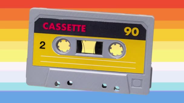 A sequence of cassette tapes with different plain labels and colourful lines background - Footage, Video