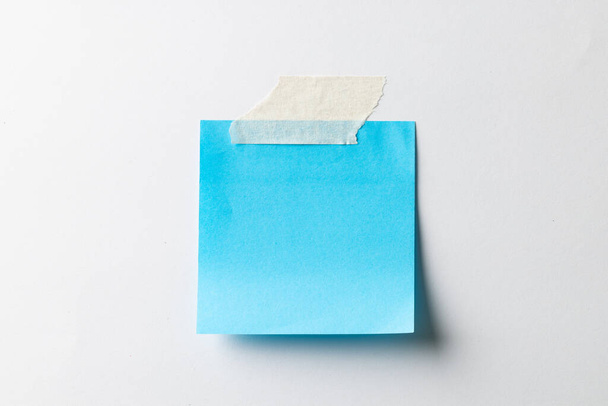 Modrá lepicí poznámka s kopírovacím prostorem na bílém pozadí. Abstraktní papírová textura pozadí a komunikační koncept. - Fotografie, Obrázek