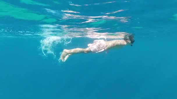 Niño usando máscara de buceo nadando bajo el agua - Metraje, vídeo