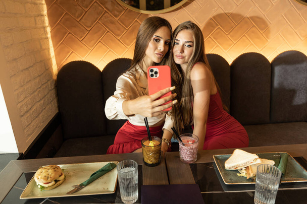 Two girlfriends taking selfie in a cafe bar - Fotografie, Obrázek
