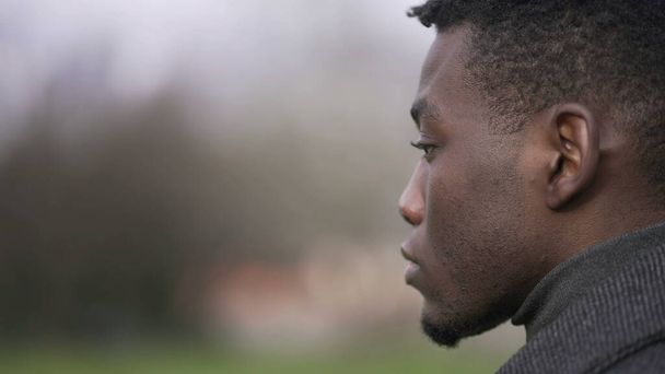 Thoughtful African black man standing outside at park thinking - Valokuva, kuva