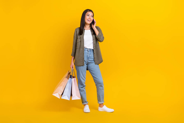 Full length photo of young excited popular star blogger speaking phone want order more black friday offers isolated on yellow color background. - Fotoğraf, Görsel