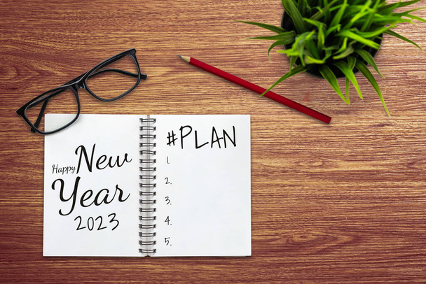 2023 Happy New Year Resolution Goal List and Plans Setting - Business office desk with notebook written about plan listing of new year goals and resolution setting. Koncepcja zmiany i ustalenia. - Zdjęcie, obraz