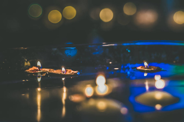 notendop met brandende kaarsen drijvend op wateroppervlak in donkere, Europese kersttraditie - Foto, afbeelding