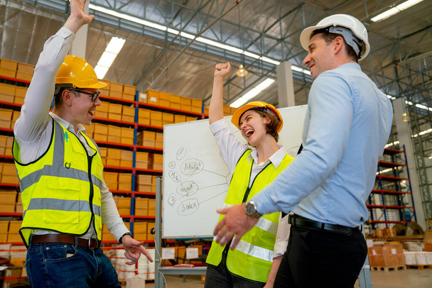 Τρεις από τους καυκάσιους αποθηκάριους εργάτες σηκώνουν τα χέρια ψηλά για να δείξουν δράση ευτυχίας και να γιορτάσουν με επιτυχία την εργασία τους στον χώρο εργασίας. - Φωτογραφία, εικόνα