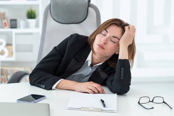 Zmęczony sfrustrowany i przepracowany kobieta biznesu siedzi w biurze i myśli o problemach w biznesie - Zdjęcie, obraz