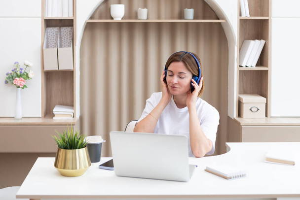 Young attractive woman in headphones studying online at home. Distance education concept - Φωτογραφία, εικόνα