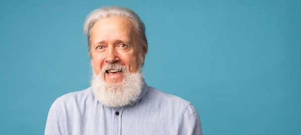 Portrait de bannière de cheveux gris surpris barbe grand-père vieil homme sur fond de couleur bleue avec espace de copie - Photo, image