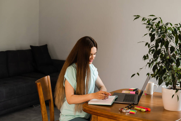 Studente intelligente ragazza con laptop studio inglese online presso la scuola di lingue a casa. Attraente giovane donna hanno lezione di comunicazione video con l'insegnante - Foto, immagini