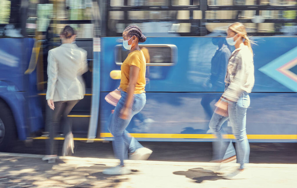 Women, covid travel and bus stop in city morning commute, public transportation or local travelling in motion blur. Diversity, passenger and covid 19 face mask in vehicle healthcare safety compliance. - Foto, Imagen