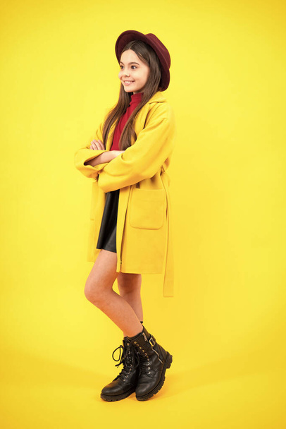Autumn clothes. Full length of cheerful teenager child girl wearing comfy trendy fashion clothes, isolated over yellow background. Happy teenager portrait. Smiling girl - Fotó, kép