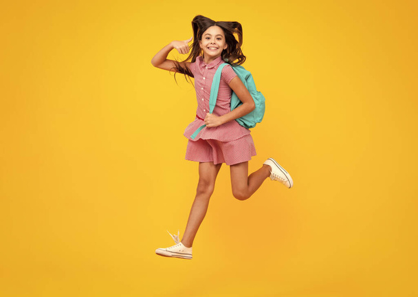 Koulu teini tyttö reppu. Teini-ikäinen opiskelija eristyneellä taustalla. Hullu juoksu ja hyppy. Lasten oppiminen, koulutus, opiskelu ja osaaminen - Valokuva, kuva