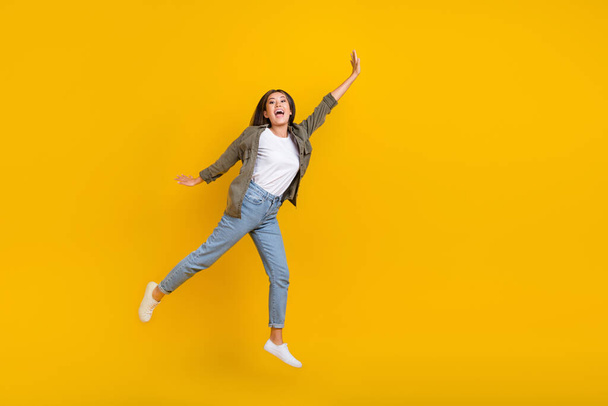 Full body size photo of young crazy japanese addicted shopaholic lady jumping air raise arm up empty space isolated on yellow color background. - Foto, Imagem