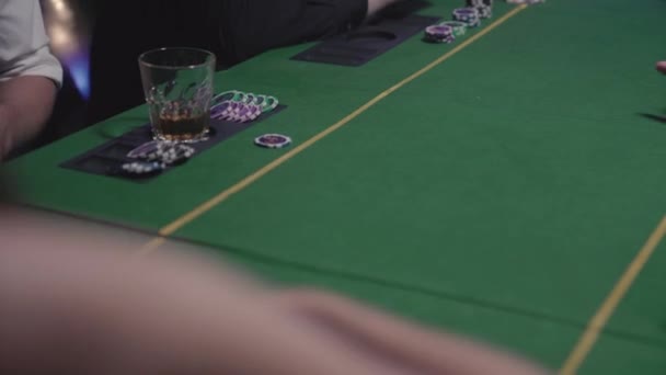 Poker masasında kumar oynayan adamlar. Kadın oyunculara kart dağıtır. Her oyuncuya masaya fırlatır. - Video, Çekim