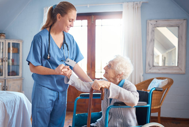 Старшая женщина, инвалидное кресло и медсестра для взятия за руки, поддержки инвалидов или дома престарелых. Пожилая женщина, врач и консультации для помощи, консультации или физиотерапии в уходе за пожилыми людьми, клиника или улыбка на работе. - Фото, изображение