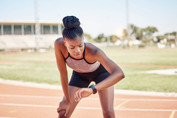 Siyah kadın, fitness ve runner izleme egzersizi, egzersiz ya da spor pist zamanı için saati kontrol ediyor. Aktif Afro-Amerikan kadın performans takibi için koşan sporda akıllı saate bakıyor. - Fotoğraf, Görsel