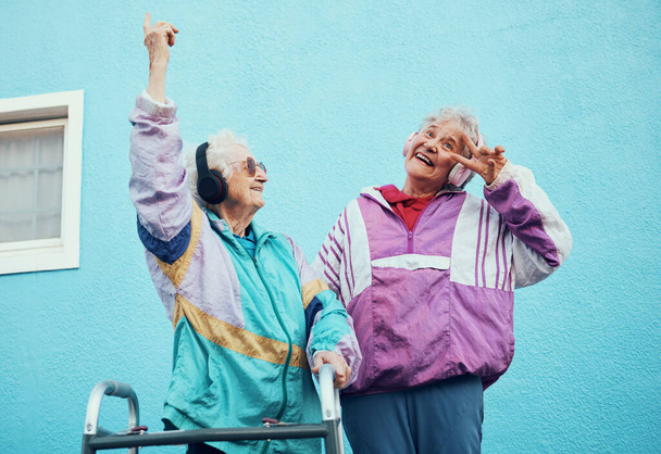 Senior, music and disability with a woman friends outdoor in a city having fun together with a peace sign hand gesture. Freedom, retirement and happy with a mature female and friend bonding outside. - Фото, зображення