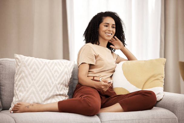 Happy, woman and watching tv on a sofa, relax and laughing at comedy, movie and film in her home. Television, black woman and streaming show, entertainment and humour on a couch in a living room. - Фото, зображення
