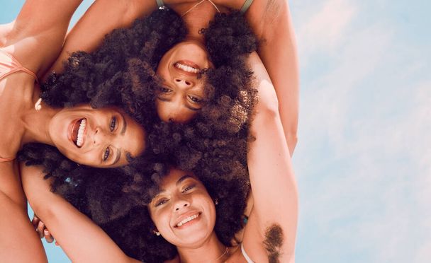 Beauty, community and afro friends in a circle, relax, smile and blue sky while having fun together. Freedom, face and happy women embracing in a trust huddle, excited at a social gathering outdoor. - Foto, Imagem