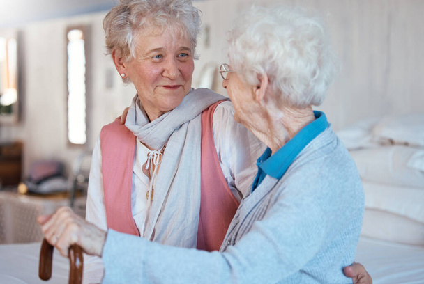 Onnellisia, ystäviä ja seniorinaisia juttelemassa ja sitoutumassa vanhainkodin makuuhuoneessa. Onnellisuus, keskustelu ja eläkkeellä olevat vanhukset naisten parhaat ystävät hymyillen juoruista puhuen huoneessa. - Valokuva, kuva