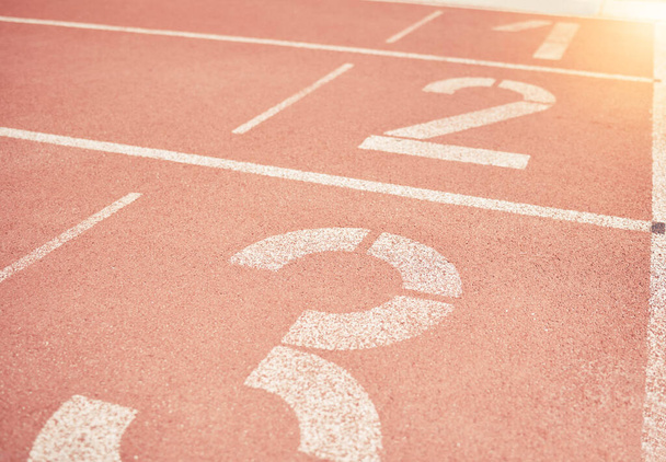 Sports, athletics and number on race track in stadium for training, sprint and running start position. Texture, ground and running track with nobody for fitness, exercise and workout for sport event. - Photo, Image