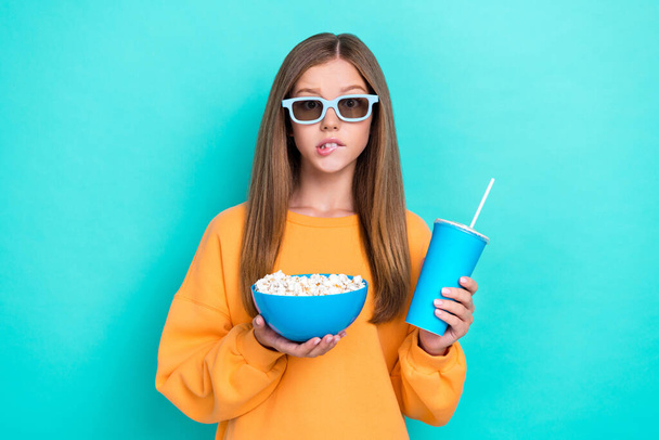 Photo of cute teenager girl brown long hair hold popcorn drink soda fanta beverage bite lips look 3d glasses isolated on cyan color background. - Fotoğraf, Görsel