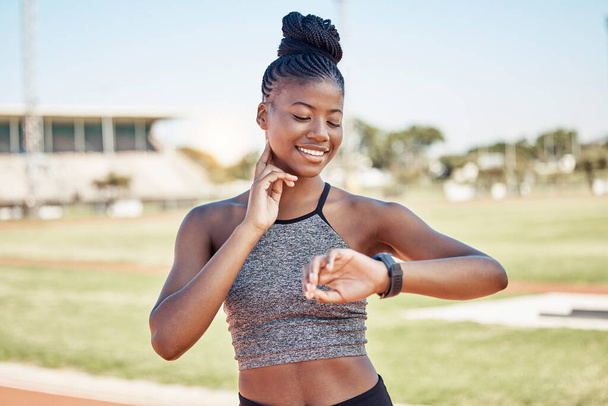 Fitness, smartwatch and heart rate with black woman running on stadium track for training, sprinting or stamina endurance. Goals, tracker and progress app with runner checking time for cardio workout. - Fotó, kép