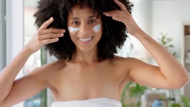 Face mask, cream and black woman happy about skincare beauty, wellness and facial. Portrait of a woman with a smile in a bathroom or spa busy with healthy, dermatology and cosmetic eye lotion. - Footage, Video