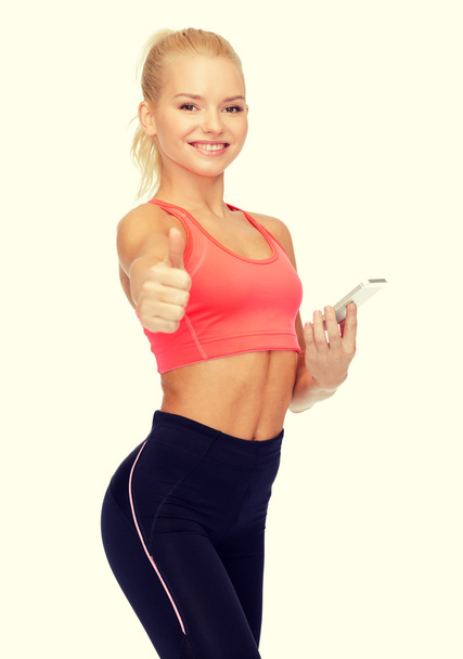 smiling sporty woman with smartphone - Zdjęcie, obraz