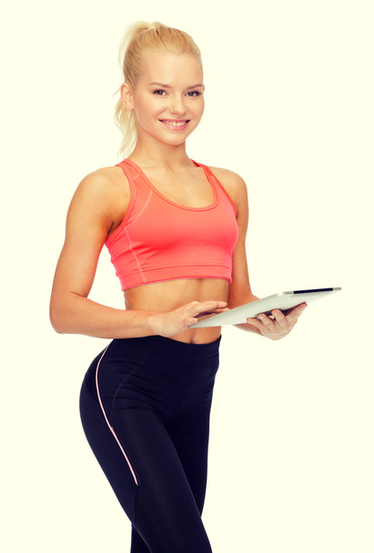 smiling sporty woman with tablet pc computer - Фото, зображення