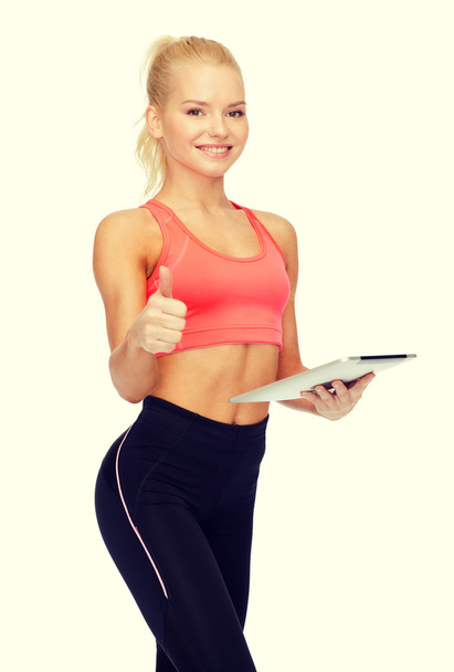 smiling sporty woman with tablet pc computer - Foto, afbeelding