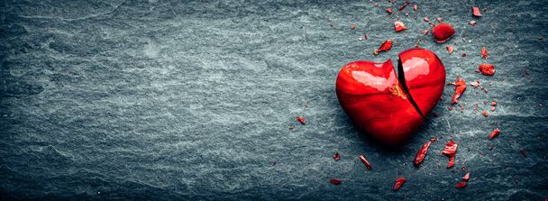 Red Glass Heart Laying Broken On Cold Stone Floor - Концепция отношений  - Фото, изображение