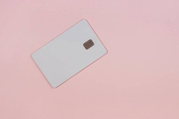 White credit card with chip isolated on the pink background, real photo - Foto, afbeelding