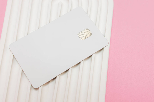 White credit or debit card with chip on the wavy white stone surface, mock-up - Foto, Imagem