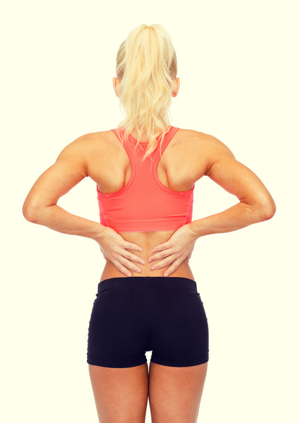 sporty woman touching her back - Foto, Bild
