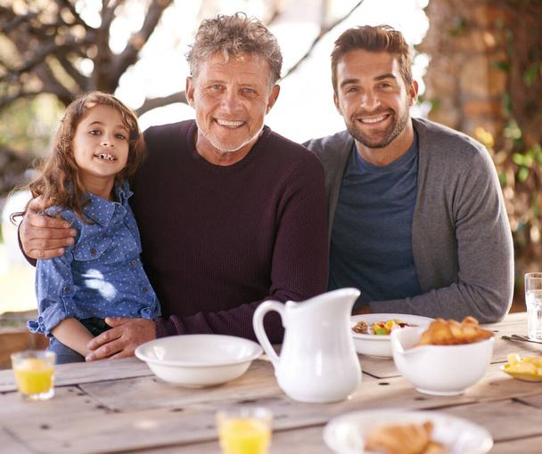 Zegen het eten voor ons en de familie naast ons. Portret van een gelukkige multi-generationele familie die samen ontbijten buiten - Foto, afbeelding