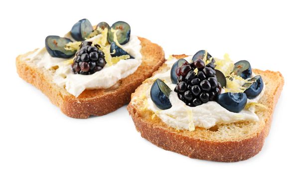 Tasty sandwiches with cream cheese, blueberries, blackberries and lemon zest on white background - Foto, Imagem