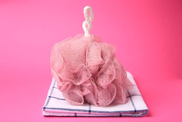New shower puff and towel on pink background - Foto, Bild