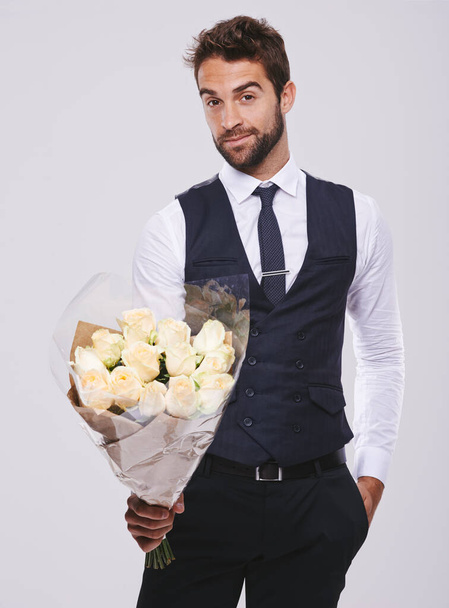 These are for you. Studio shot of a handsome and well-dressed young man - Φωτογραφία, εικόνα