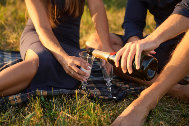 Pár zamilovaný pije šampaňské z brýlí při západu slunce - Fotografie, Obrázek