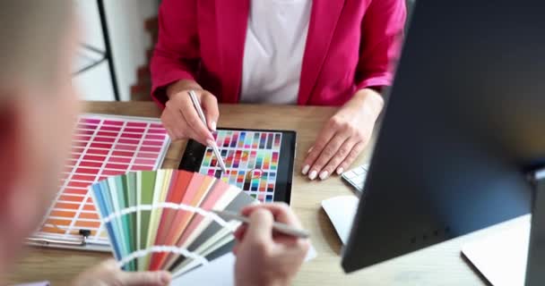 Οι άνθρωποι στο γραφείο επιλέγουν ένα δείγμα από μια παλέτα χρωμάτων, ένα κοντινό πλάνο. Στούντιο σχεδιαστών, συνδυασμός χρωμάτων - Πλάνα, βίντεο